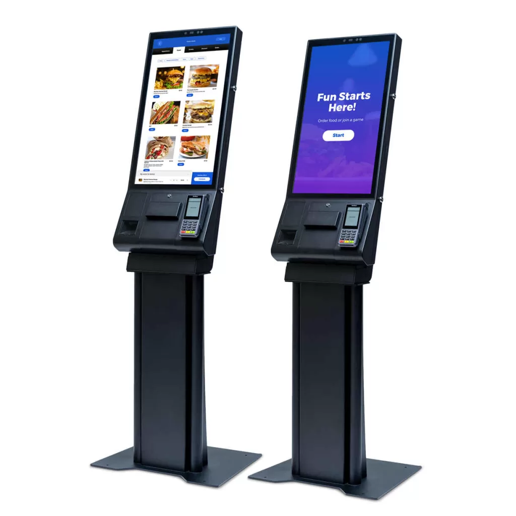 Have More Fun Bowling with Brunswick Sync Service Kiosks – A pair of sleek, black self-service kiosks with touchscreen displays, one showing a digital menu with food options and the other displaying a welcome screen.