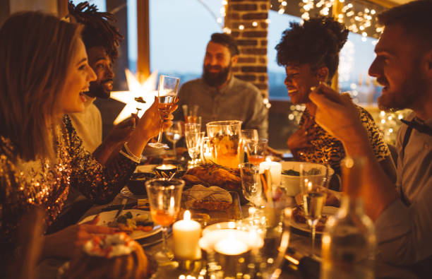 Multi ethnic group of friends having new year dinner party, everyone enjoying in food and drink